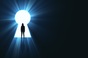 Backlit person in hoodie standing in bright keyhole opening on dark background with mock up place...