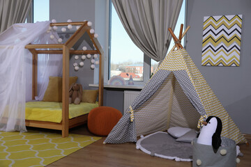 Stylish child room interior with comfortable house bed and play tent