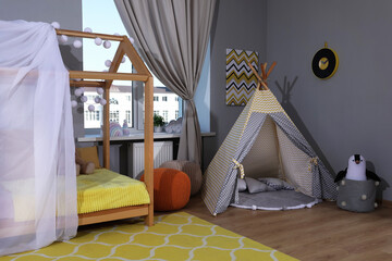 Stylish child room interior with comfortable house bed and play tent