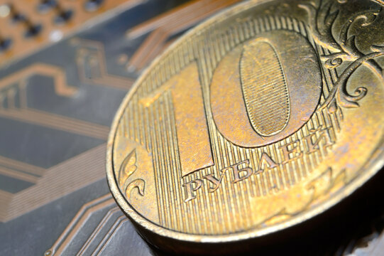 A coin with a face value of 10 rubles lies on a microcircuit. close-up. Translation of the inscription on the coin: "10 rubles" The concept of the digital economy in the Russian Federation