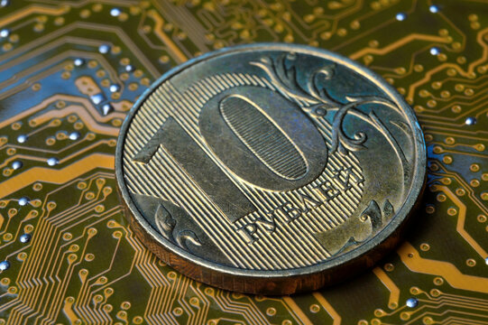 A coin with a face value of 10 rubles lies on a microcircuit. close-up. Translation of the inscription on the coin: "10 rubles" The concept of the digital economy in the Russian Federation