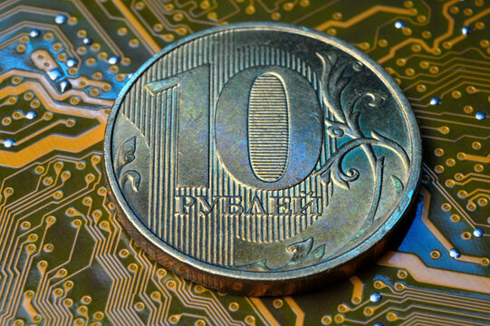 A coin with a face value of 10 rubles lies on a microcircuit. close-up. Translation of the inscription on the coin: "10 rubles" The concept of the digital economy in the Russian Federation