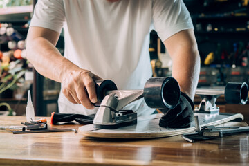 man repairing wheel of skateboard in workshop, Skateboard maintenance and repair concept. Selective focus