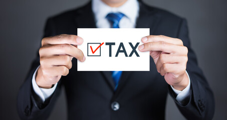 Businessman hand holding paper tax