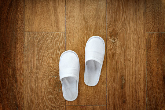 Disposable white slippers on hotel room floor