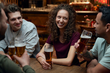 Group of friends having beer and socializing in a pub