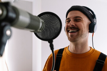 Happy freelancer with microphone singing at home studio
