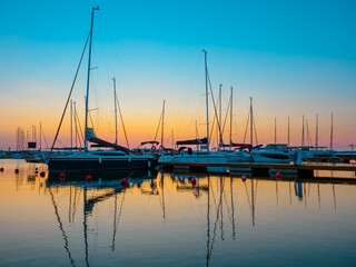 dawn landscape of quayside with jetty full of sailing yachts, calm, tranquil and serenity waterfront view