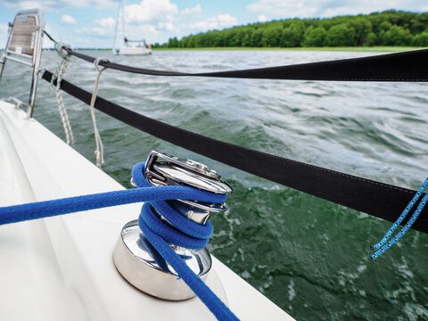 close up photo of sailboat or yacht winch wrapped with blue rope