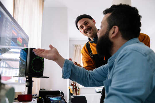 Musicians Discussing Over Computer At Home Studio