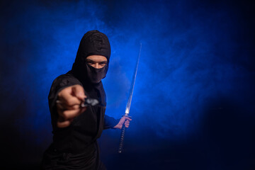 Medieval warrior ninja assassin throws shuriken in smoke