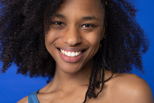 Happy Young Woman With Afro Hairstyle Against Blue Background