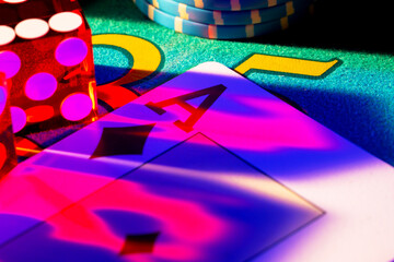 Ace of diamonds, set chips and dice on poker game table in casino. Poker set close up. Red blue light falls on game card. Concept of gambling, casino betting. Entertainment in a gambling club.