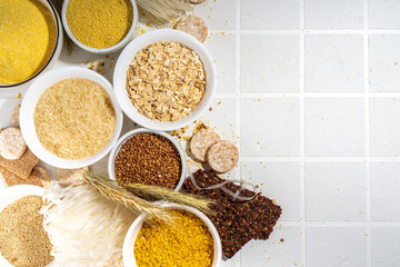 Selection of whole grains gluten free cereals. Set of various non-gluten cereals: rice, buckwheat, corn groats, quinoa, millet, oats, buckwheat, bulgur, porridge, barley, white background copy space
