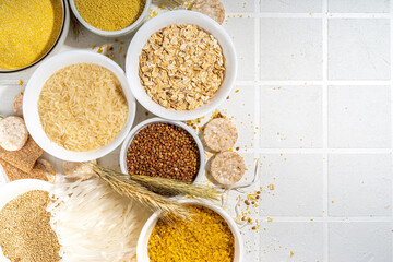 Selection of whole grains gluten free cereals. Set of various non-gluten cereals: rice, buckwheat, corn groats, quinoa, millet, oats, buckwheat, bulgur, porridge, barley, white background copy space