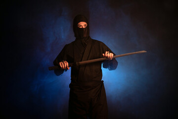 Medieval warrior assassin ninja with sword in aggressive pose in smoke © Fotokvadrat