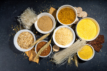 Selection of whole grains gluten free cereals. Set of various non-gluten cereals: rice, buckwheat, corn groats, quinoa, millet, oats, buckwheat, bulgur, porridge, barley, black background copy space