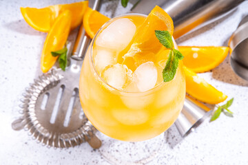 Orange and mint alcohol cocktail, aperol spritz, mimosa drink in long cocktail glass, with fresh...