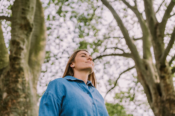 Young woman inhaling fresh air in nature