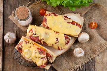 Pizza sandwich on a wooden table, top view. Pizza on a baguette.