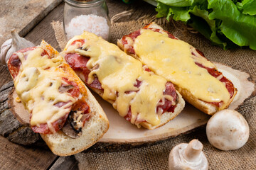 Pizza sandwich, pizza on a baguette with sausages and cheese close-up.