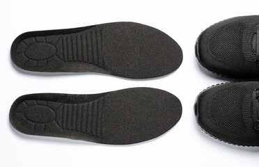Orthopedic insoles and sports sneakers. White background. The concept of prevention of foot diseases