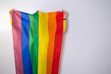 Caucasian woman holding lgbt flag covering herself. 
