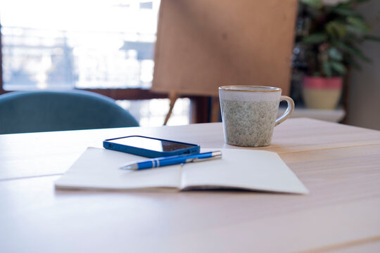 Diary With Smart Phone And Coffee Mug On Table At Home