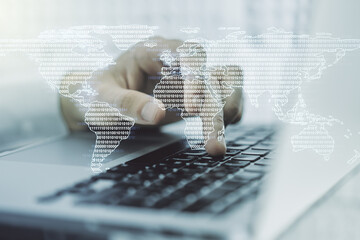 Double exposure of abstract digital world map and hand typing on laptop on background, big data and blockchain concept