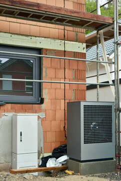 Luftwärmepumpe / Klimaanlage für Heizung und Warmwasser und Verteilerkasten an einem Wohnhaus-Rohbau