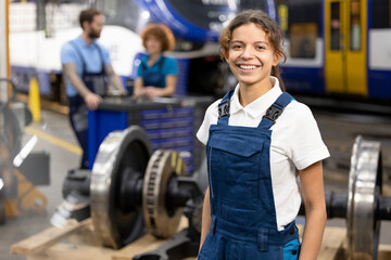 Happy young trainee standing in warehouse at industry