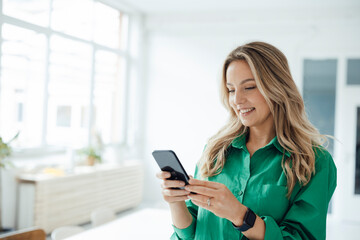 Happy woman using smart phone at home
