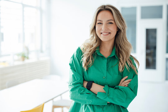 Smiling Woman Standing With Arms Crossed At Home