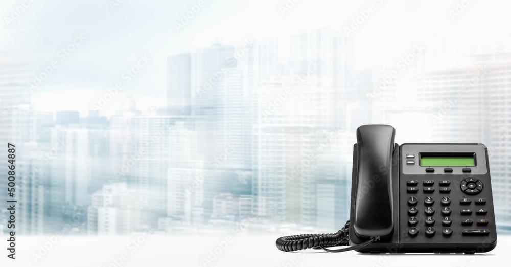 Wall mural landline telephone with voip on white table on blurred city background. customer service support, ca