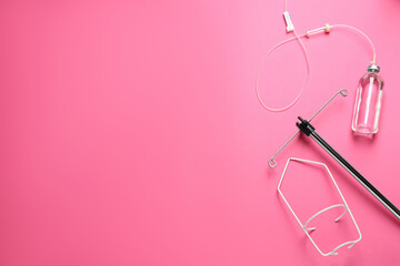 IV infusion set on pink background, flat lay. Space for text