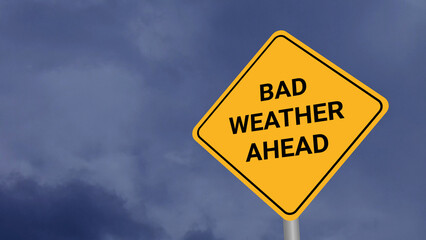 Bad Weather Ahead Road Sign on Clear Blue Sky with Rapid Moving Clouds for Text Placement