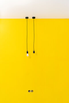 Pendant Lights Hanging From Ceiling In Front Of Yellow Wall At New Home