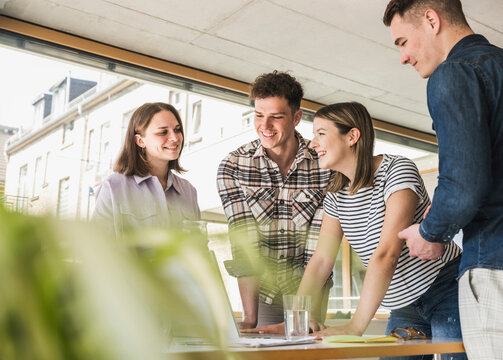 Smiling young business people having a meeting in office