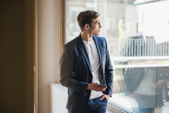 Businessman looking out of window in office