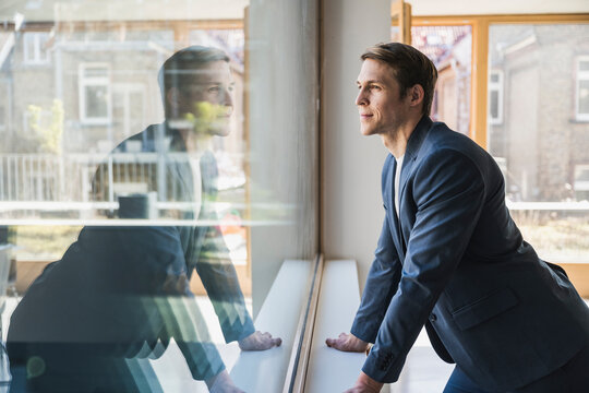 Businessman looking out of window in office