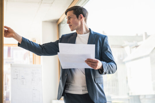 Businessman holding documents working on strategy in office