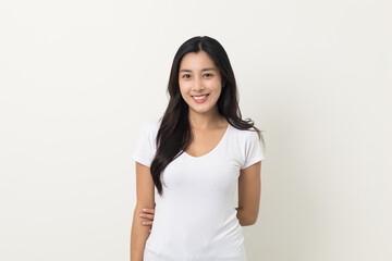 Fototapeta premium Beautiful young asian woman age around 25 smiling wearing white shirt. Charming female standing on isolated white background. Asian people pose looking camera with white backdrop.