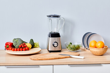Fresh fruits and vegetables with modern automatically mixer on table for making smoothie and juice