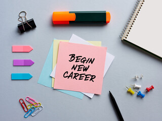 The note begin new career written on a notepaper on office desktop. Business career new beginning