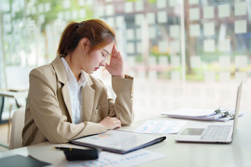 Burnout Syndrome. Portrait of Asian Business Woman feels uncomfortable working. Which is caused by...
