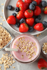Fototapeta na wymiar Jar of tasty berry oatmeal smoothie and ingredients on grey table, flat lay