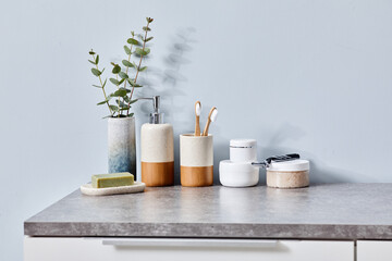 Image of toilet table with personal accessories for hygiene, creams for body care and plant in vase