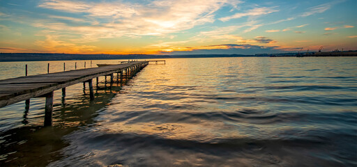 Panoramic view of stunning twilight at the shore with a wooden jetty