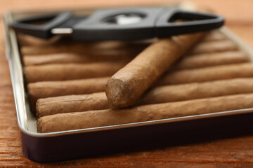 Cigars in box on wooden table, closeup