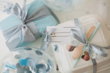 a blue gift with a card for congratulations and a balloon with confetti from stars and circles